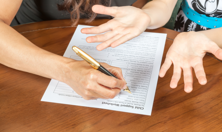 A parent filling out a child support worksheet, symbolizing the legal process of filing for child support in Canada.