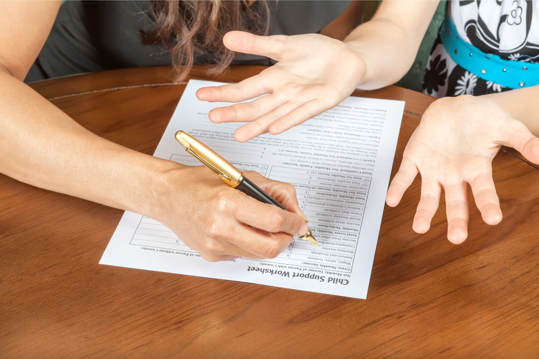 A parent filling out a child support worksheet, symbolizing the legal process of filing for child support in Canada.