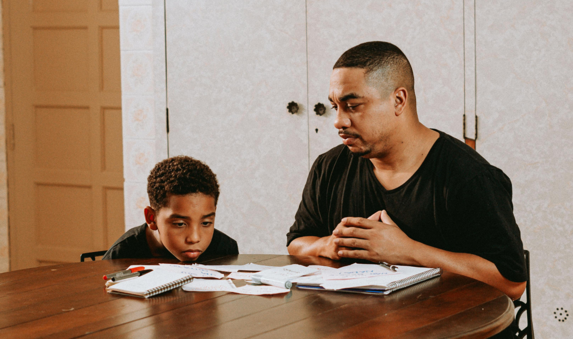 A father and son looking at financial documents, symbolizing the challenges of child support payments and financial responsibilities in Canada.