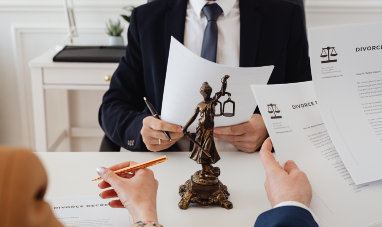 A legal consultation for divorce in Canada, with a lawyer reviewing divorce papers and a Lady Justice statue on the table.