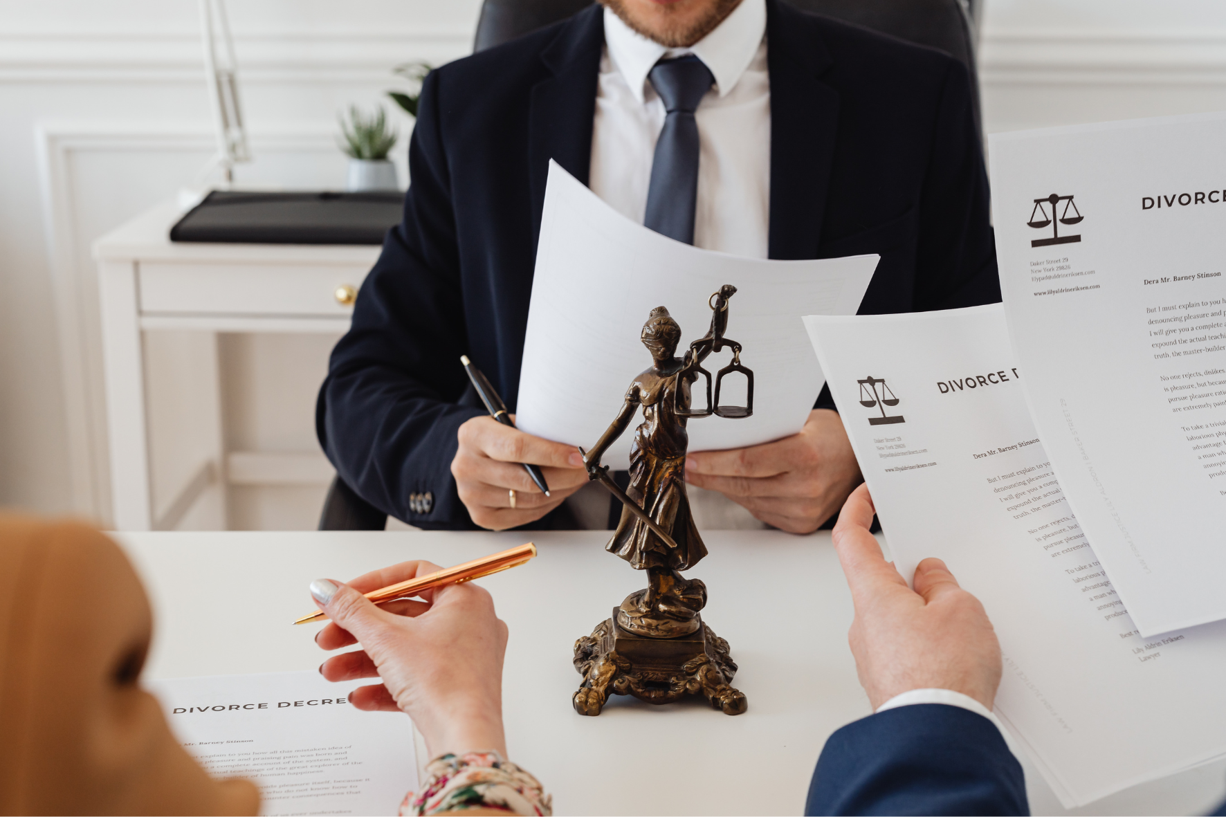 A legal consultation for divorce in Canada, with a lawyer reviewing divorce papers and a Lady Justice statue on the table.