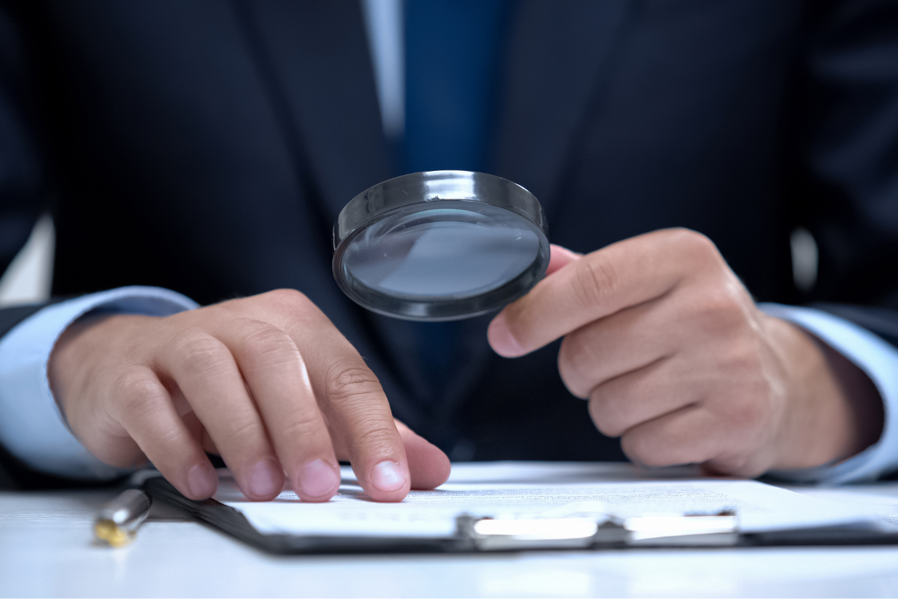 A lawyer examining legal documents with a magnifying glass, symbolizing the detailed process of filing for child custody in Ontario.