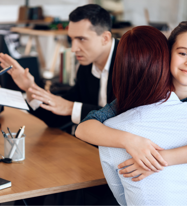 A mother hugging her smiling daughter during a custody discussion, while a lawyer mediates between parents in an Ontario child custody case.